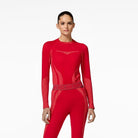 Person wearing a red baselayer for skiing with matching high boots on a white background